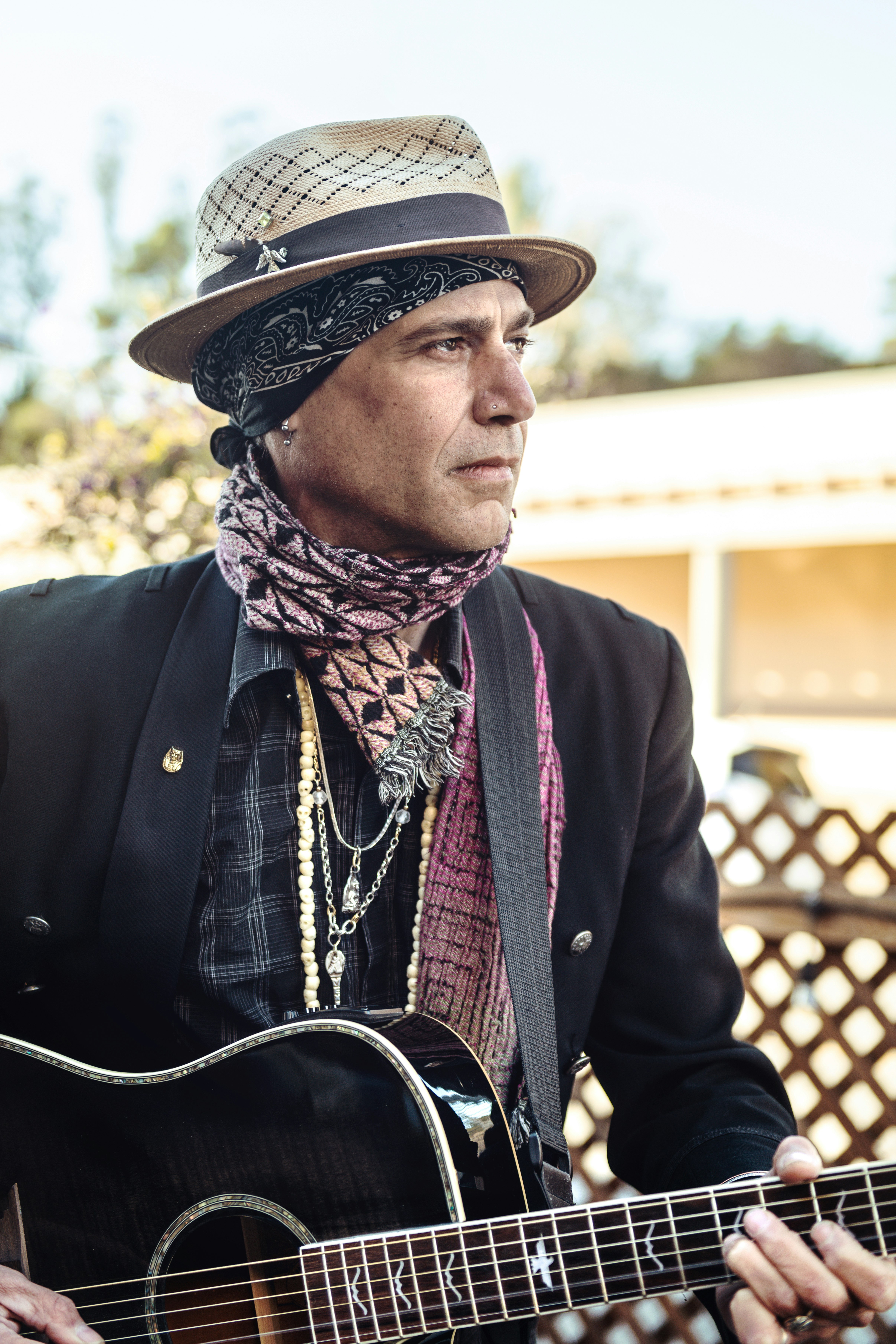 man in black button up shirt and brown and white scarf wearing black hat